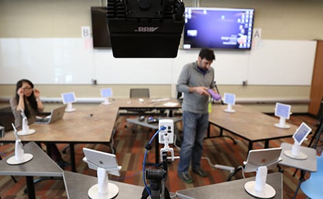 a technology room with ipad stations surrounding a technologist testing