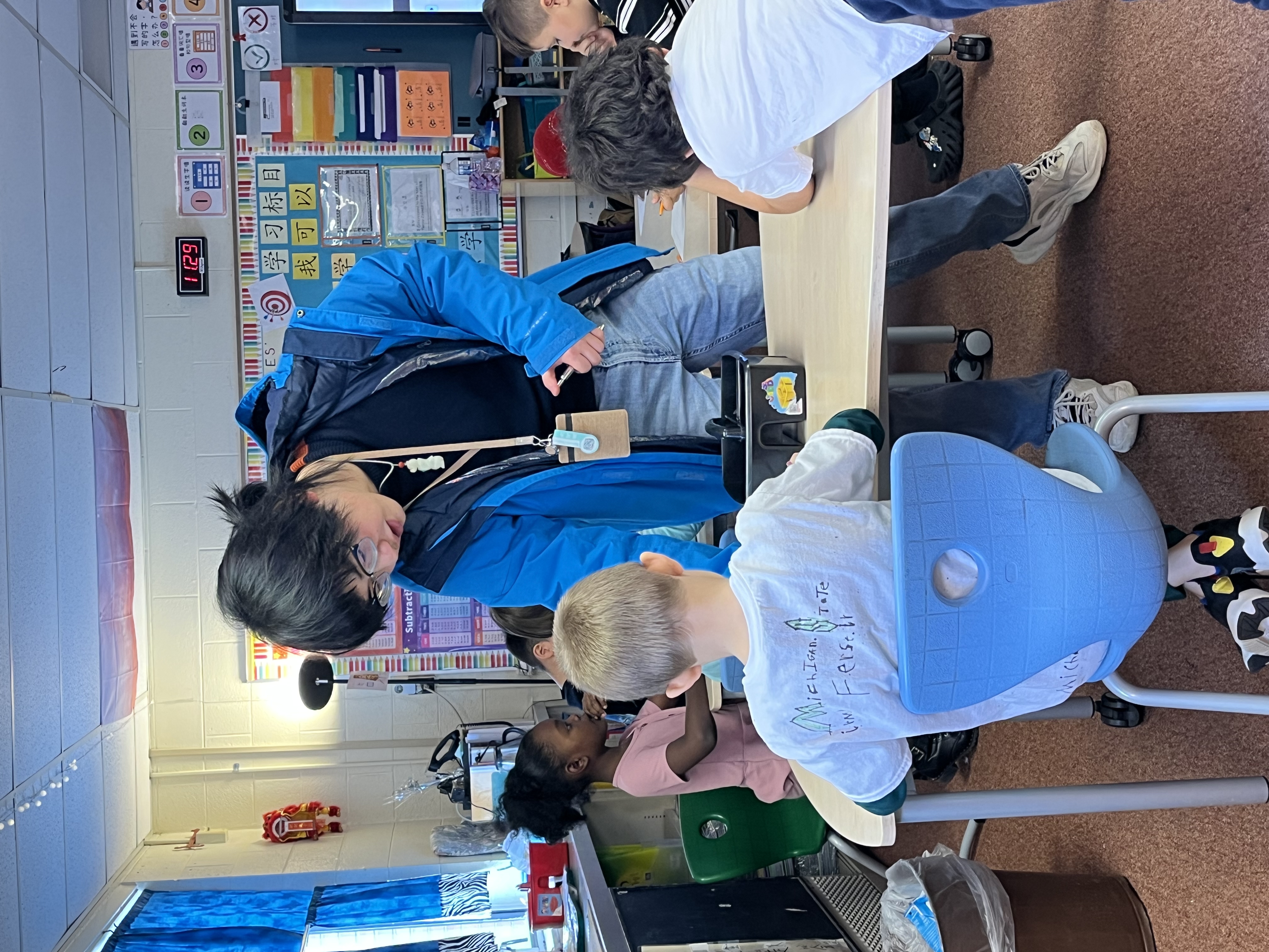 wltcp student by a child's desk giving guidance