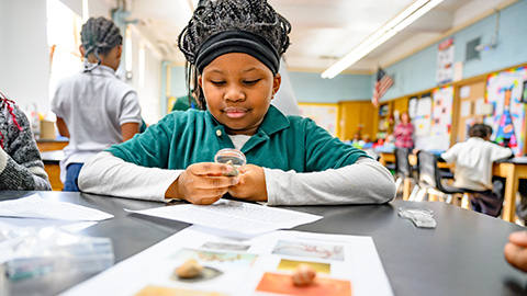 Student examines a magnifying glass during science class.