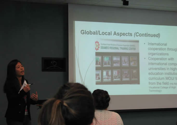 Individual gives a research presentation at the front of a room