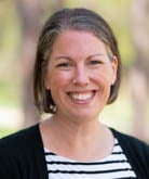 Bethany Wilinski headshot; she wears a black and white stripe shirt under a black cardigan. Her brown hair is cut about chin-length. 