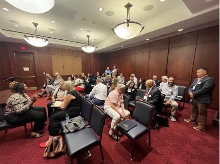 room full of people talking with each other in a conference room