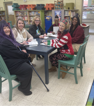 teachers sitting at a table in a classroom