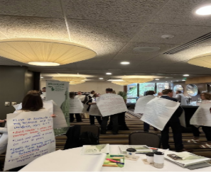 group of people holding whiteboards with their ideas on them