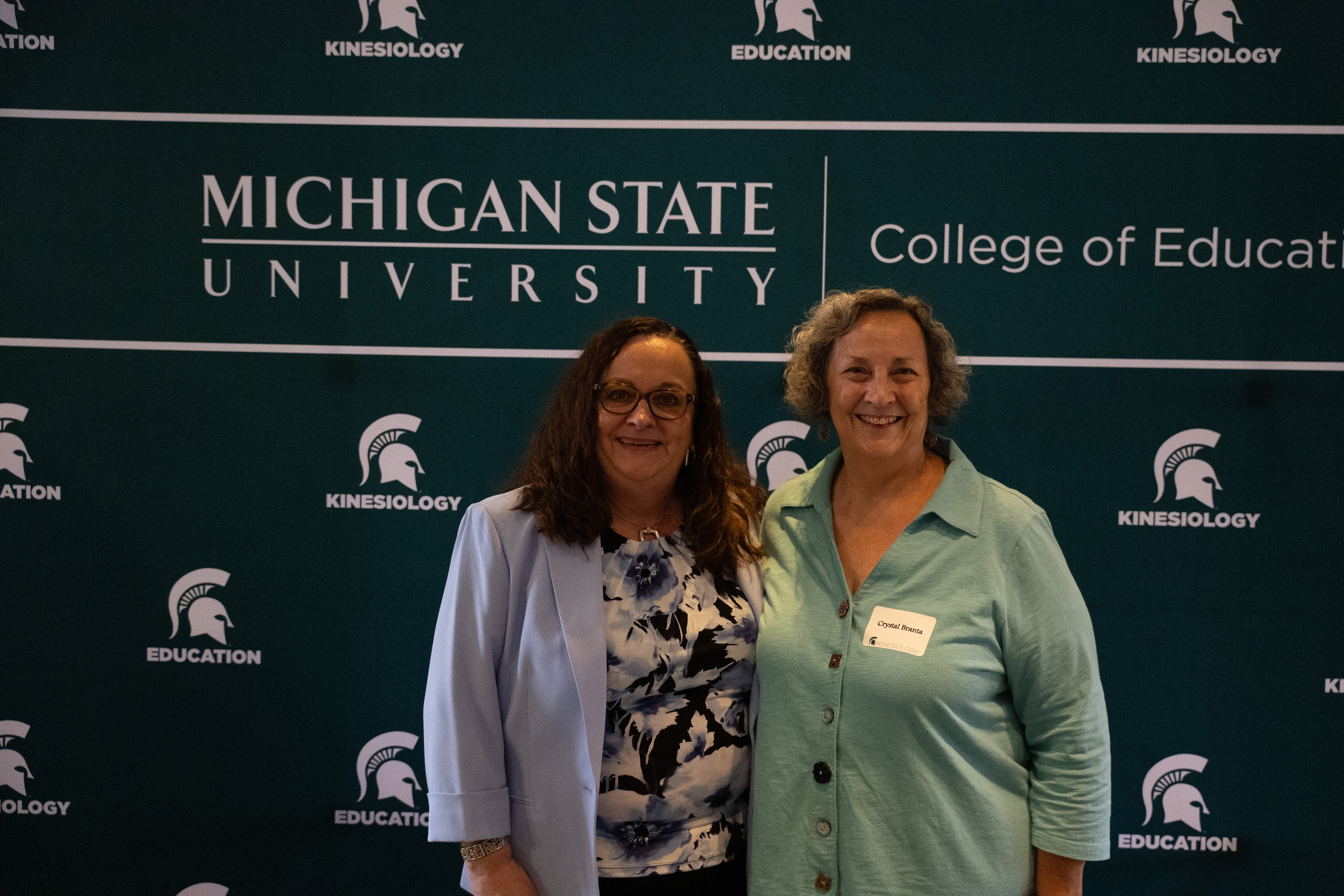 Spartans smile toward a camera (from L to R: Prof Jackie Goodway and Professor Emerita Crystal Branta)