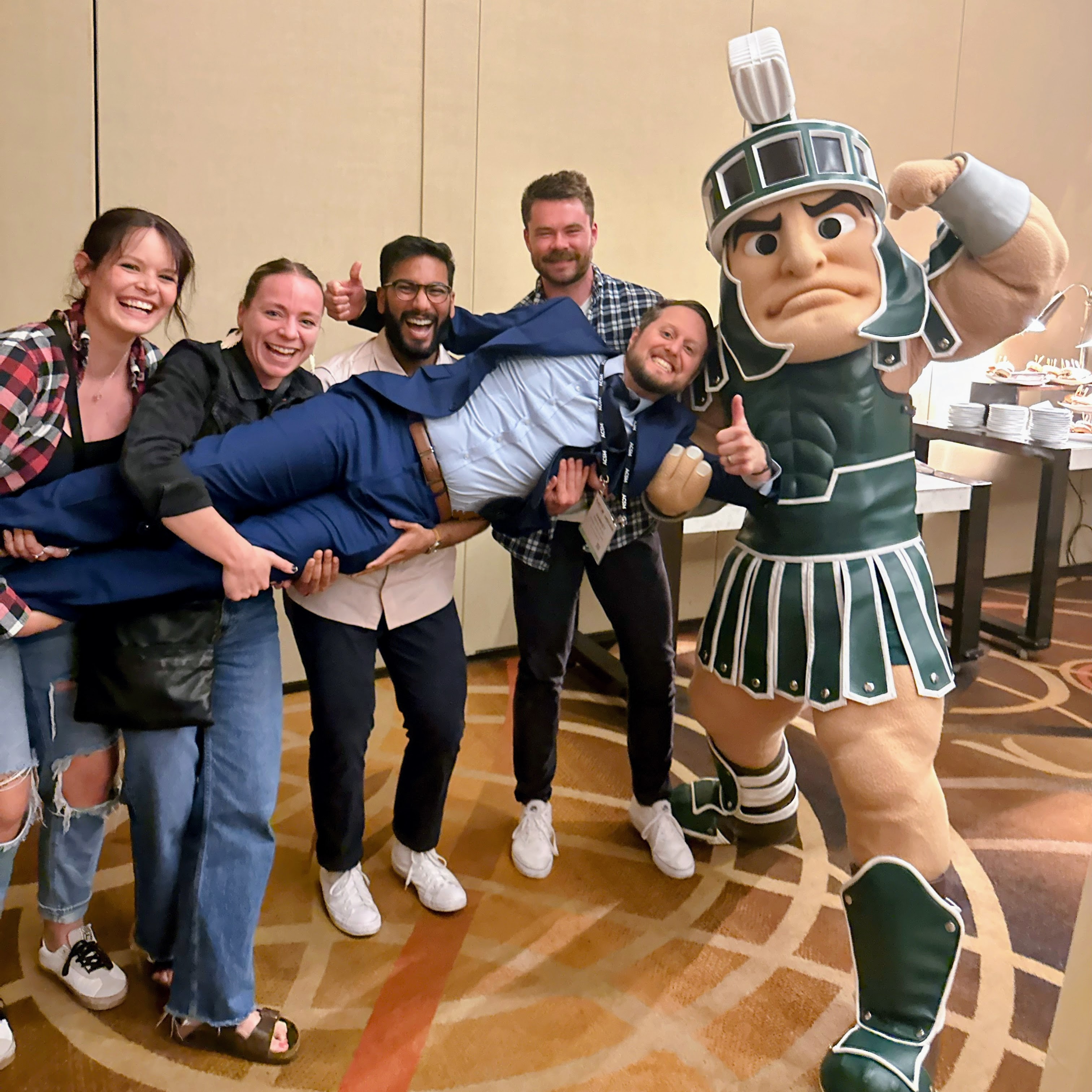 sparty and people smiling and posing for a picture