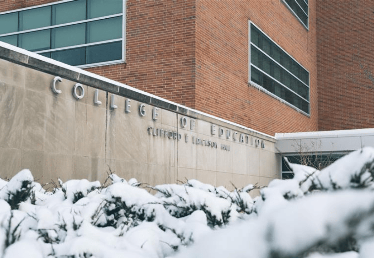 College of Education sign on the side of Erickson Hall building with snowy bushes in the foreground