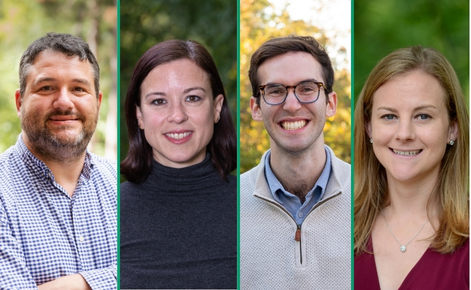 Alt text: "A group photo featuring four individuals standing outdoors. From left to right: a man with a beard wearing a checkered shirt, a woman with brown hair wearing a dark gray turtleneck, a man with glasses and brown hair wearing a light-colored sweater over a collared shirt, and a woman with blonde hair wearing a maroon top. They are smiling, with natural greenery in the background.