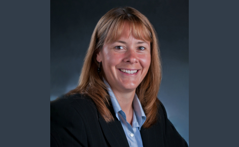 Professional headshot of Karin Pfeiffer. She is wearing a black sport coat and blue shirt.