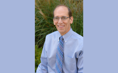 Bill Schmidt smiling wearing a light blue shirt.