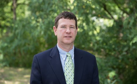 Matthew Wawrzynski standing outdoors wearing suit.