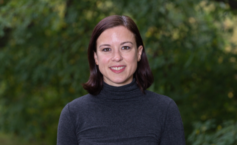 Adrea Truckenmiller headshot. Adrea wears a dark turtleneck. Adrea's brown hair is about shoulder length.