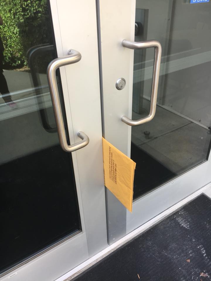 A photo of one way to apply to graduate school: Becky La submitting materials through a building door