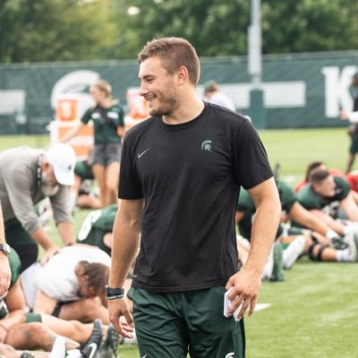 Bo Els walks among MSU football players stretching