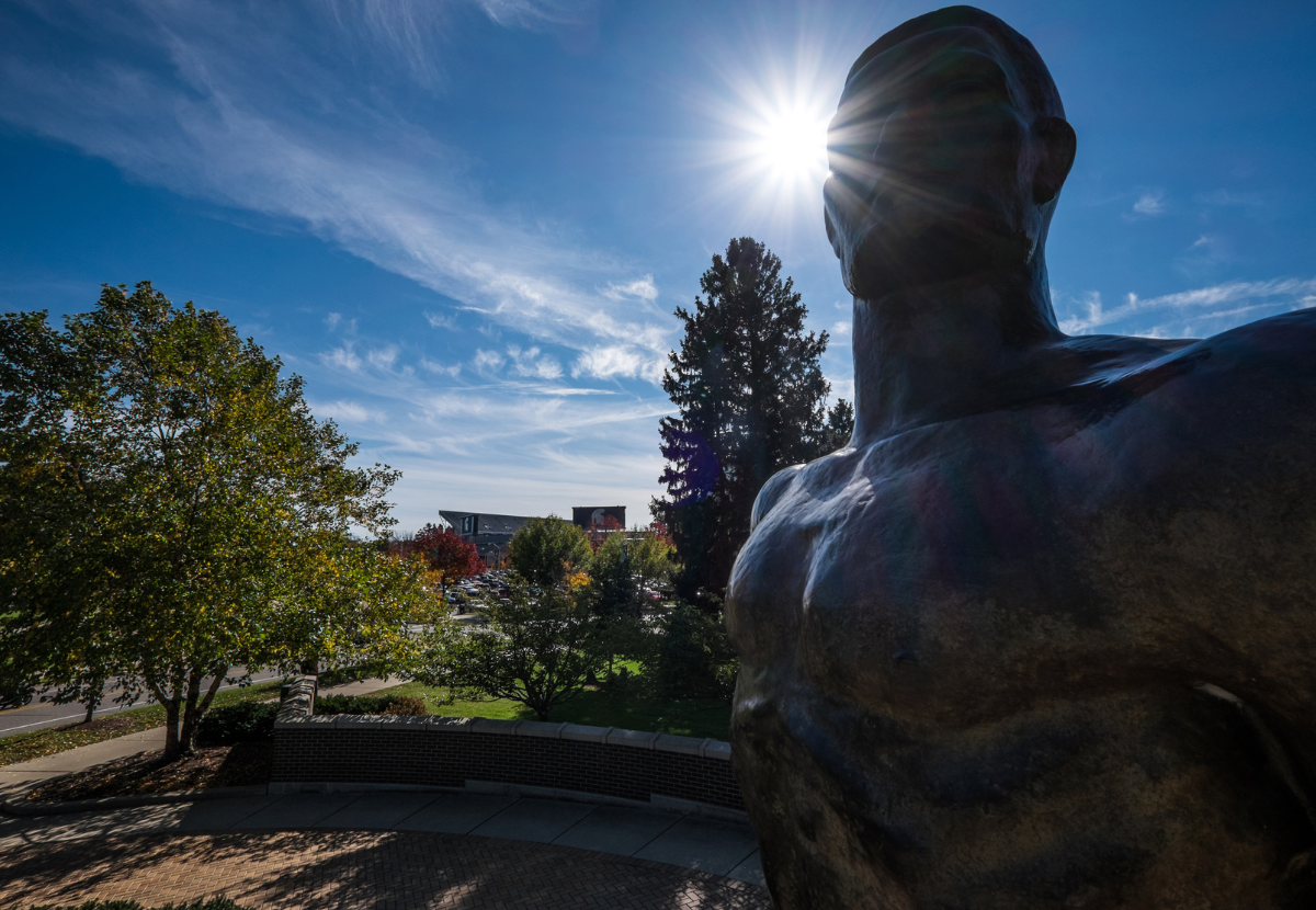 Spartan statue with the sun peeking around the top of the statue