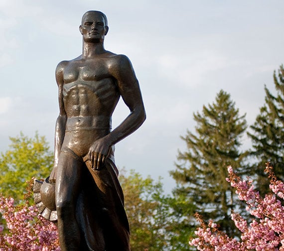 Sunny day with the focus of the MSU Spartan Statue with trees in the background