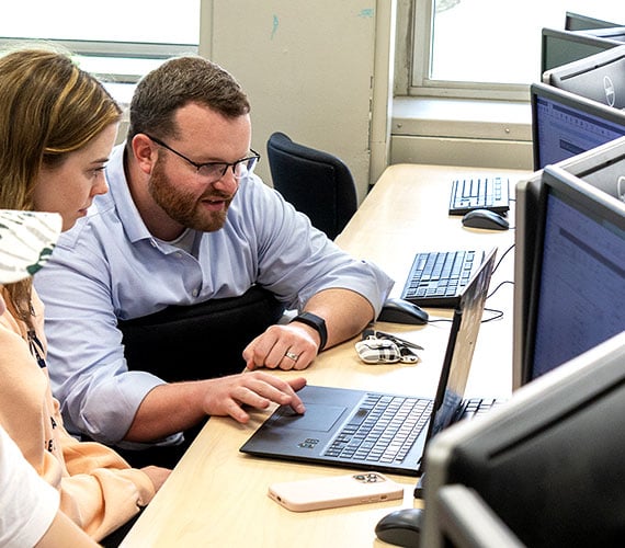 Professor Jason Smith helping his students on the computer during the EGR 102 class