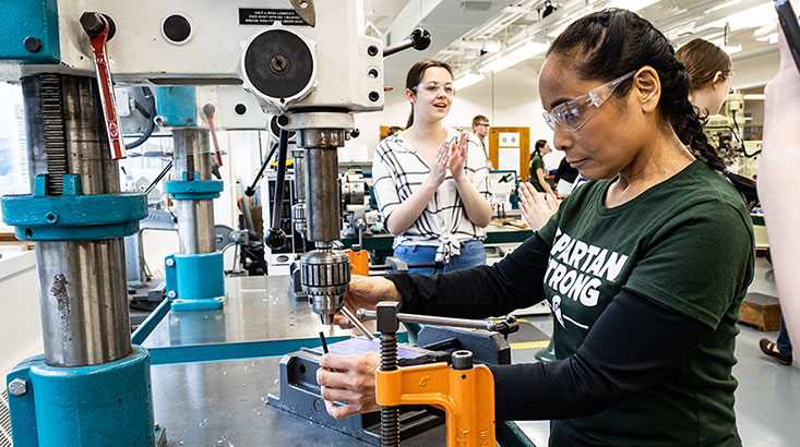 First-year student working on heavy machinery during a workshop.