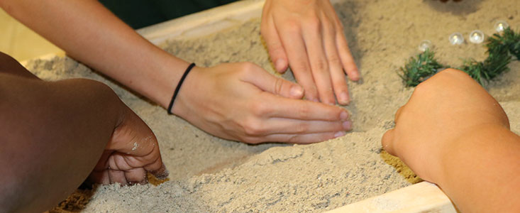 close up of hands working in a sand box during a k-12 WIE event