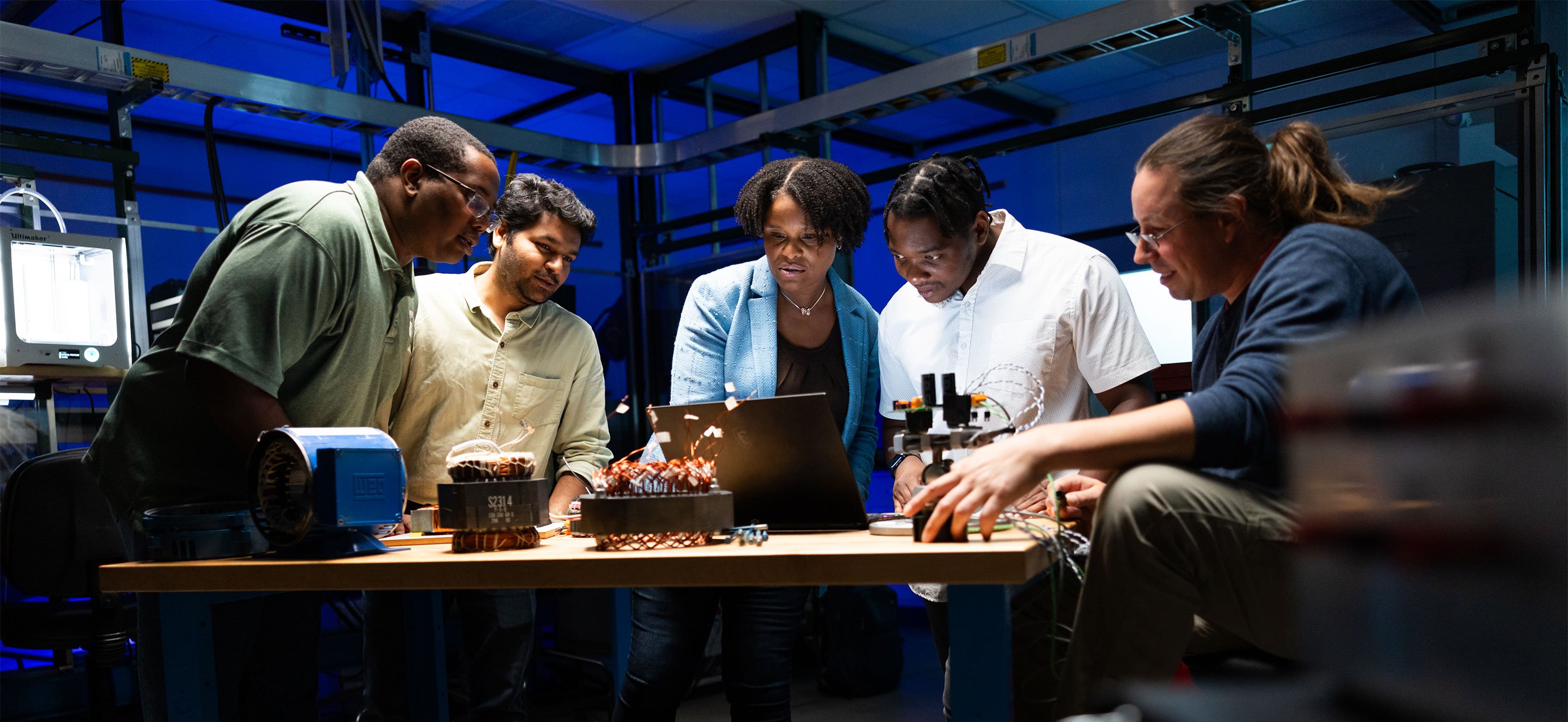 Shanelle Foster and students viewing a shared computer screen in a lab.