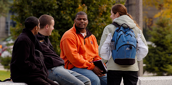 Students talking outside on MSU campus, there is a diverse group of students