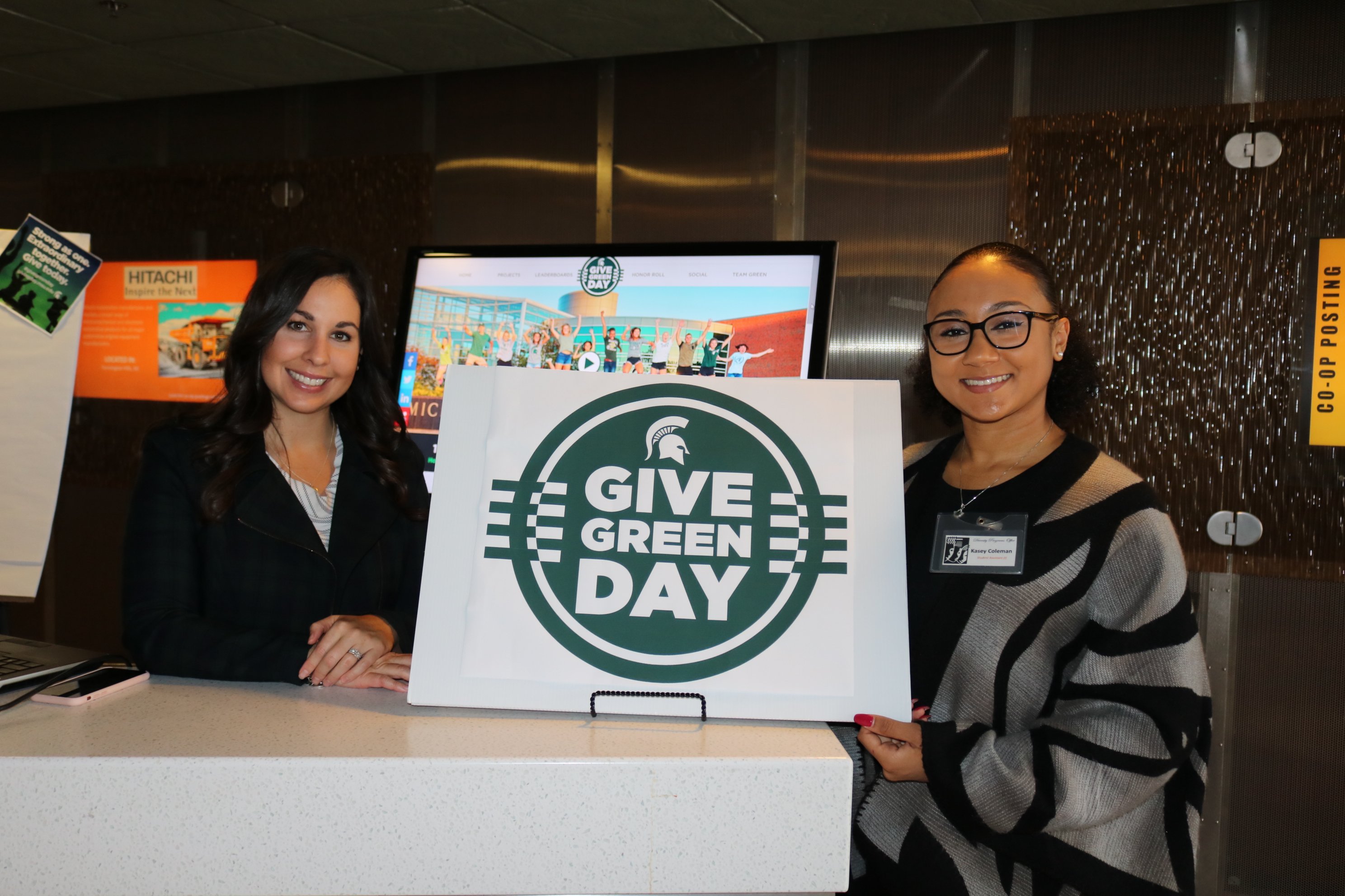 Individuals holding a Give Green Day sign