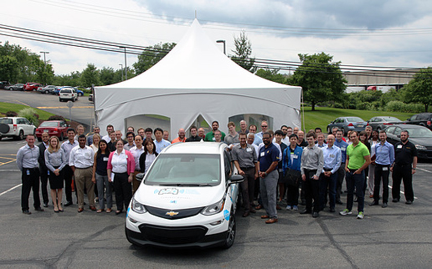 Participants in the June 5-6 kickoff workshop for the AutoDrive Challenge pose with the competition's platform vehicle, a Chevrolet Bolt, at SAE World Headquarters near Pittsburgh.