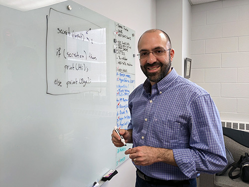 Photo of professor at the whiteboard smiling