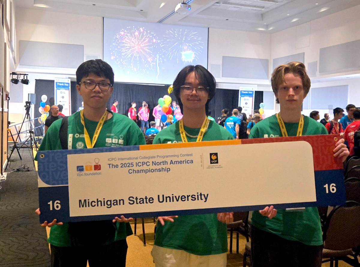 MSU ICPC team post event posing with ICPC sign that reads 'Michigan State University'