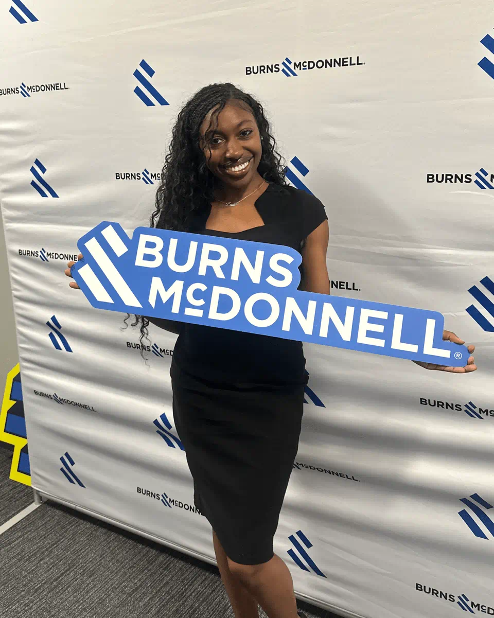 Laila Jackson posing with a Burns McDonnell sign
