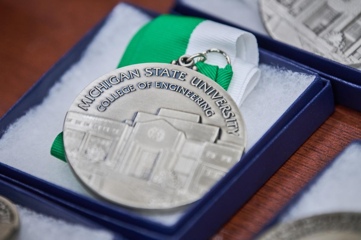 A circle silver medal that says Michigan State University College of Engineering, with a green and white ribbon
