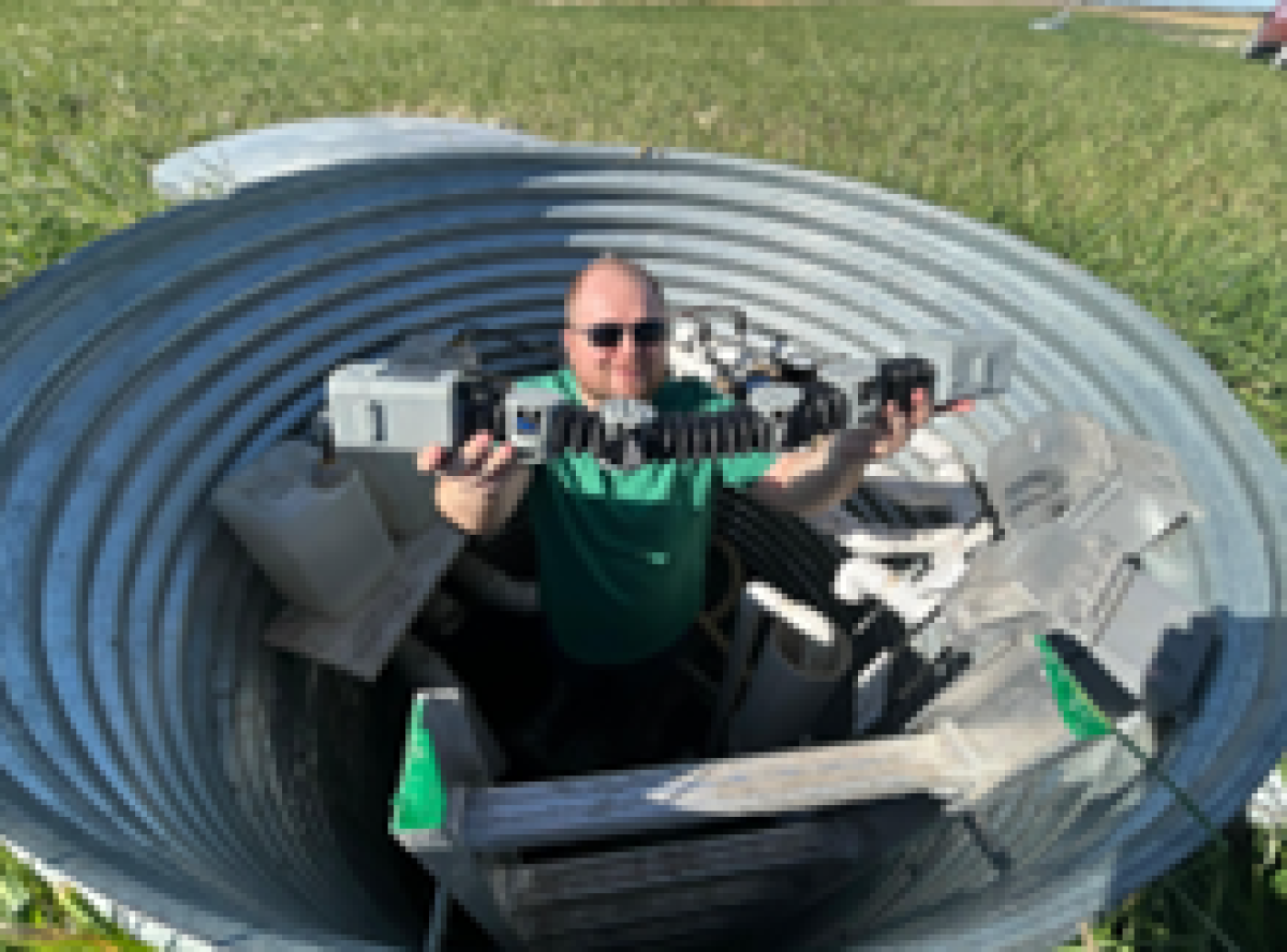 Researcher holding robot in drainage pipe