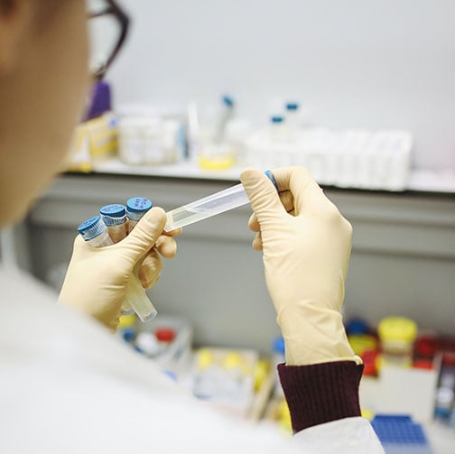 lab person in the lab holding test tubes