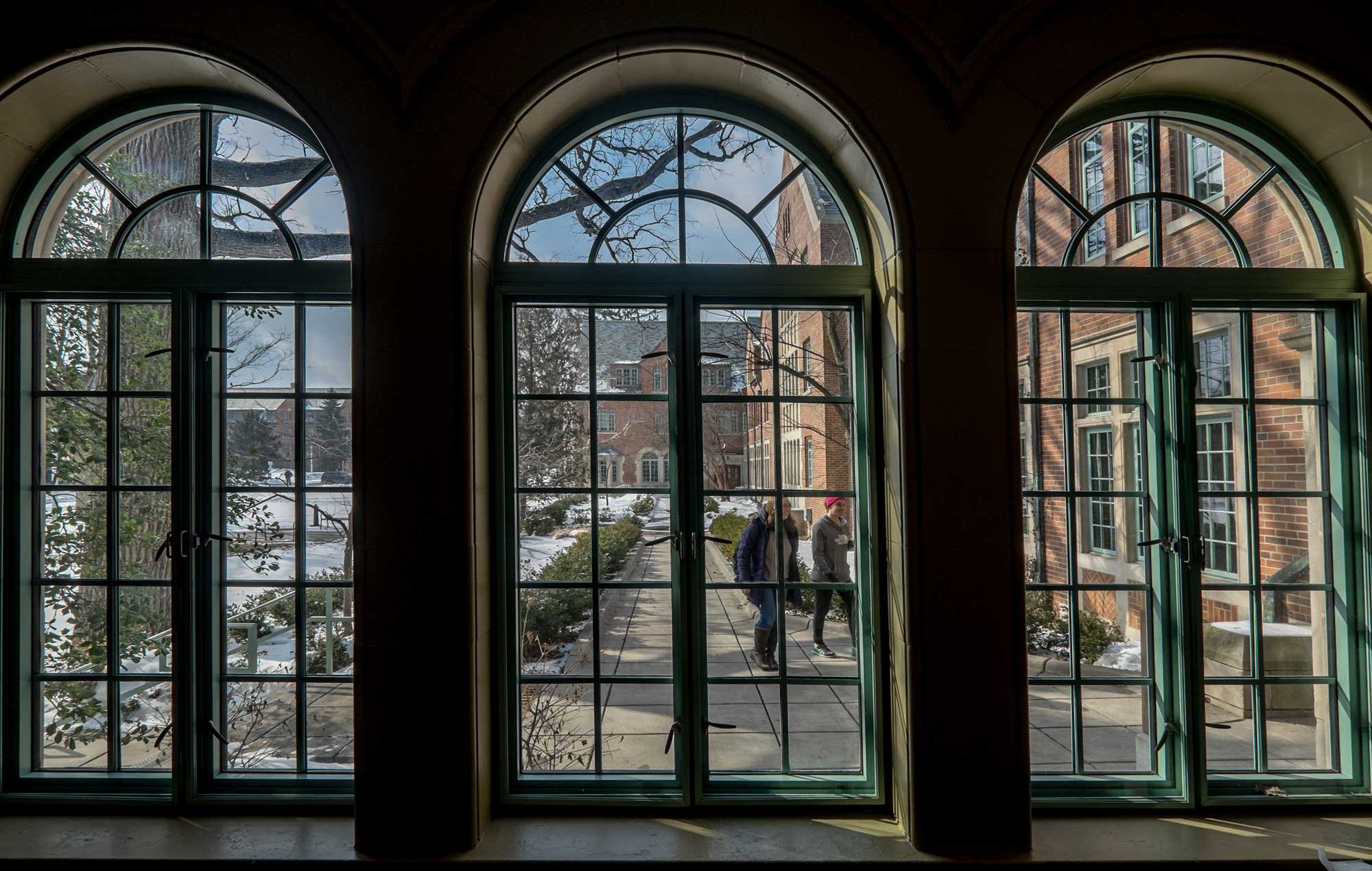 View through dorm windows of a student walking outside