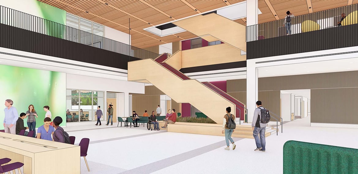 Open atrium with central staircase, seating areas, and people walking or sitting.