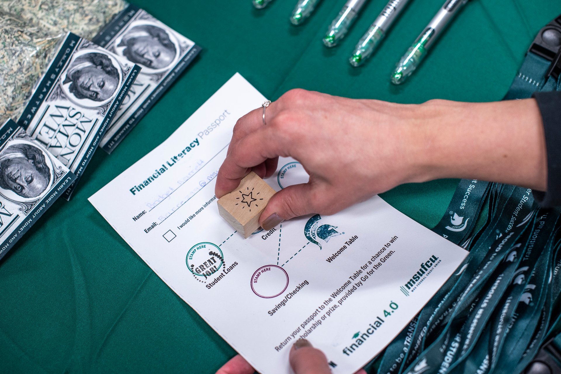 Person stamps a financial literacy passport.