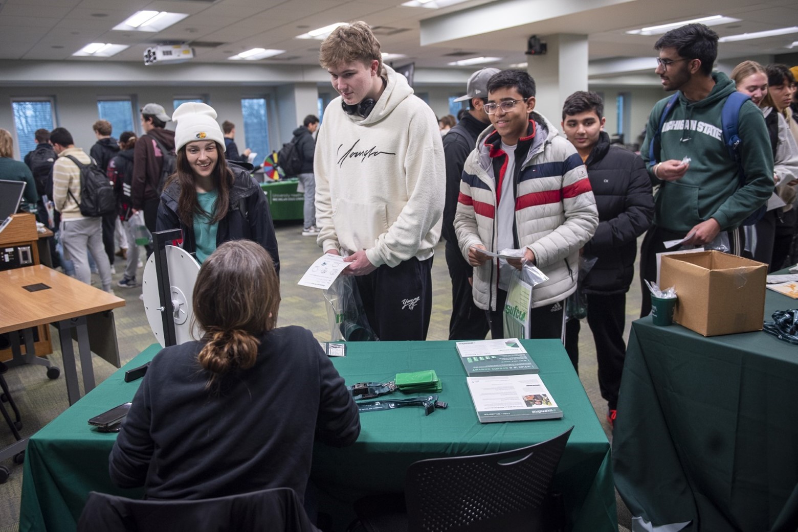 Students talk to a person at a booth.
