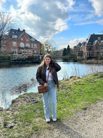 Sophia Ryan in front of a pond and brick buildings.