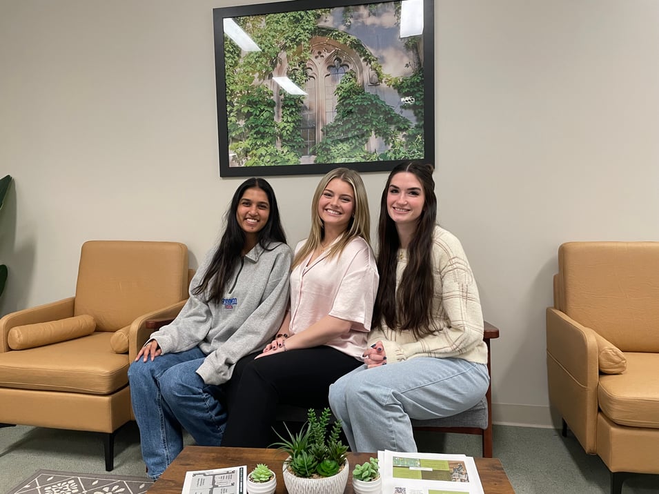 Three women interns smile in the lobby of the Couple and Family Therapy Clinic.