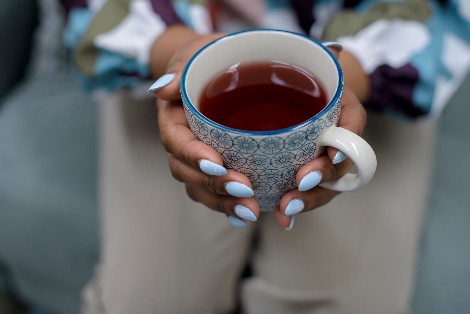 Hands holding a cup of tea.