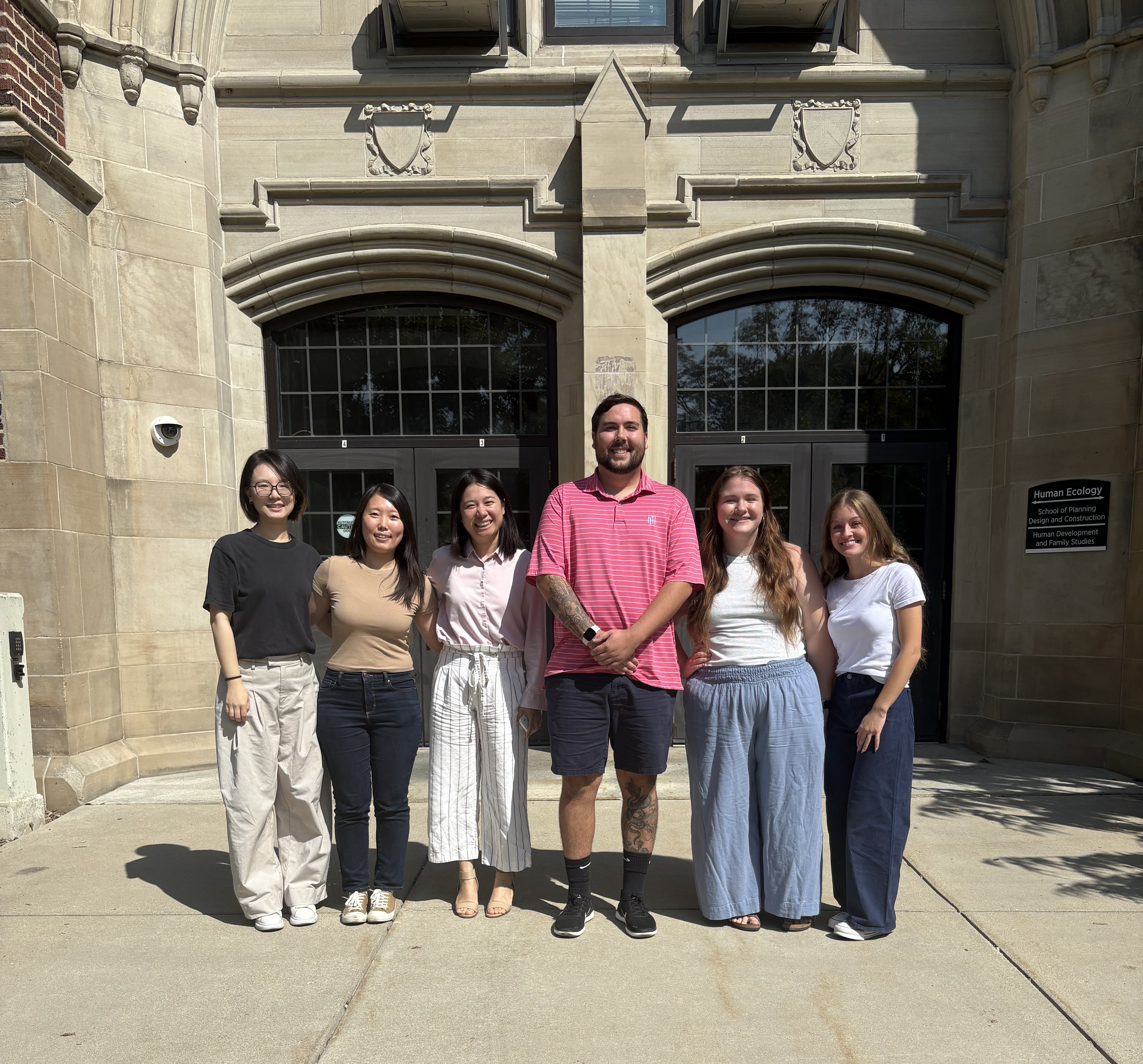 Six people stand in front of the HDFS building.