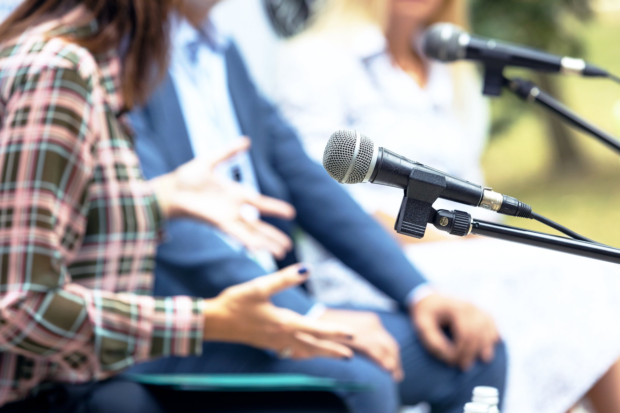 People speaking at a panel discussion.