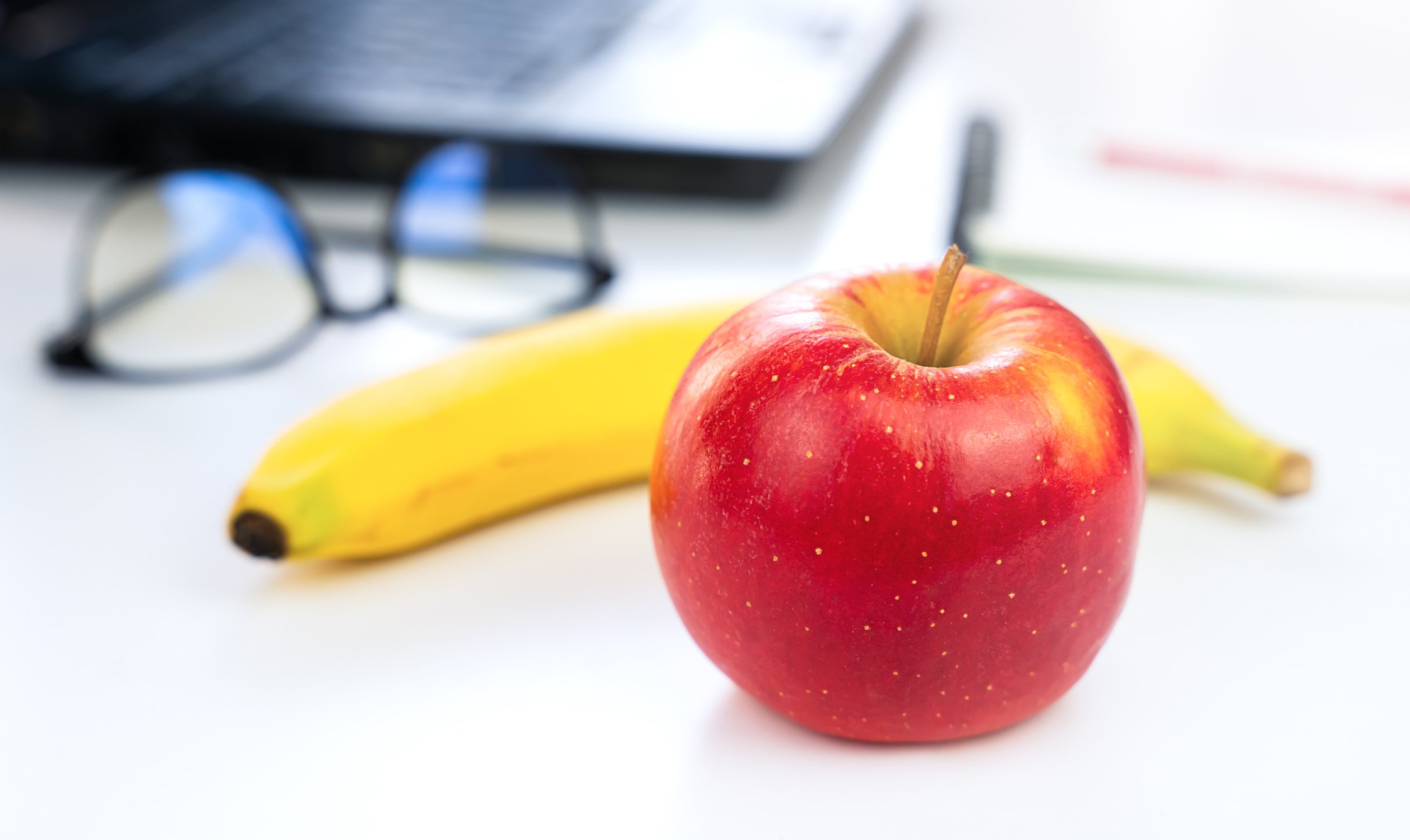 Apple and bannana on an office desk