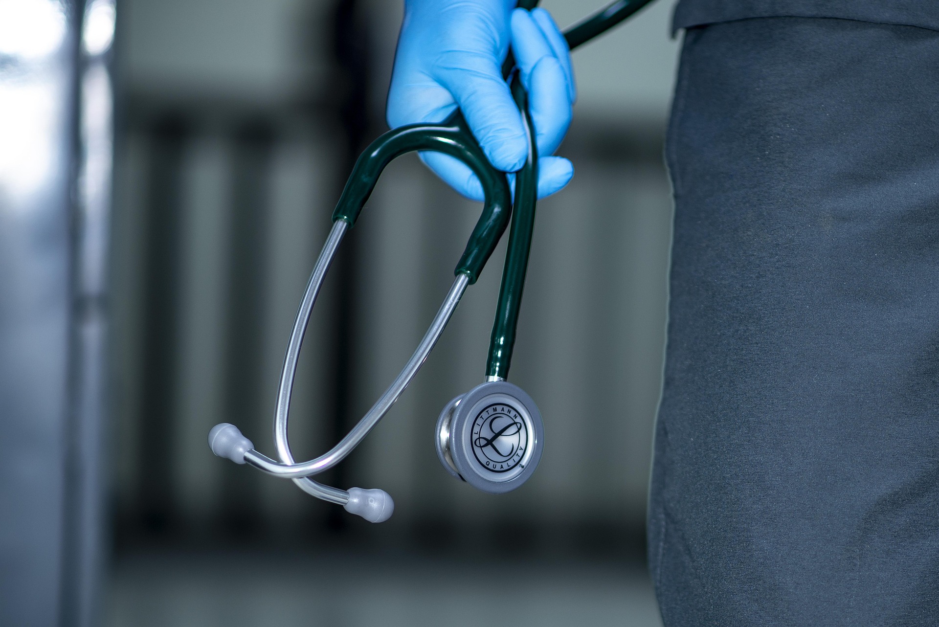 stethoscope held by a hand wearing a blue glove