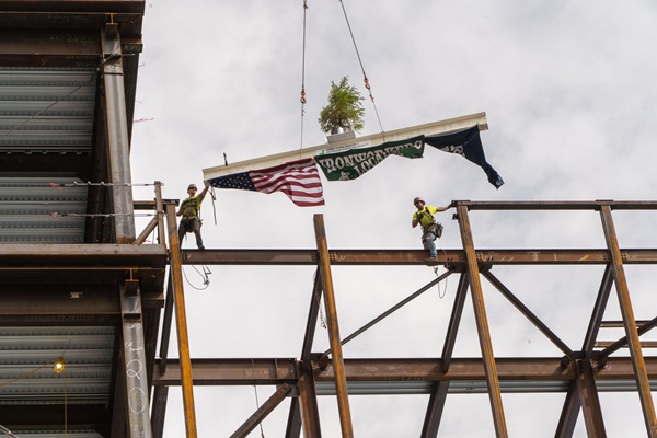 two construction men putting the beam in place