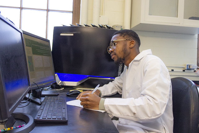 Nketsiah working at a desk in the lab