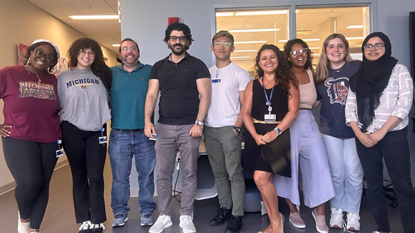 Graduate students posing together in front of the lab.