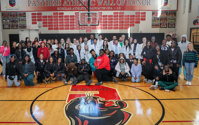 MSU CHM medical students and high school students taking a group photo in the gym.