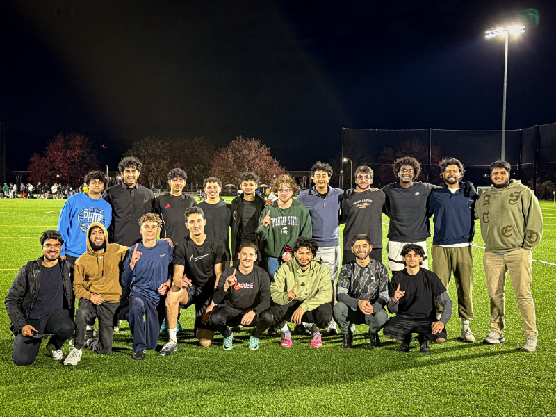 Malik and his teammates standing in a soccer field.