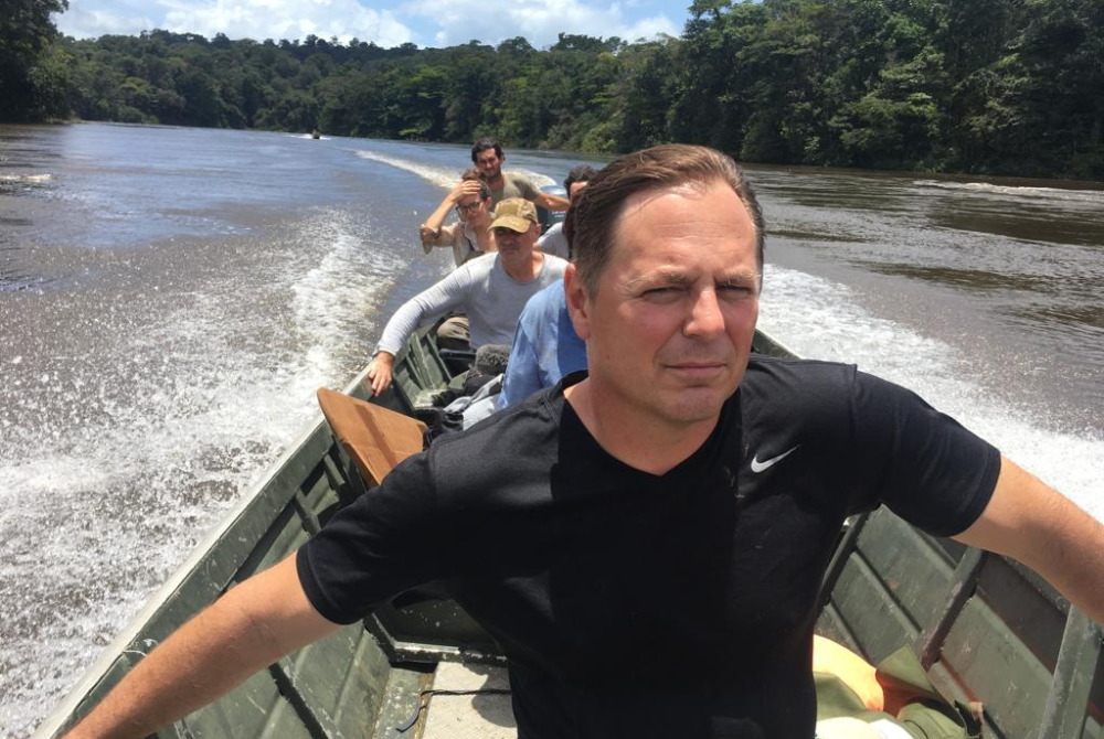Doctor Eric Benbow riding in a river boat